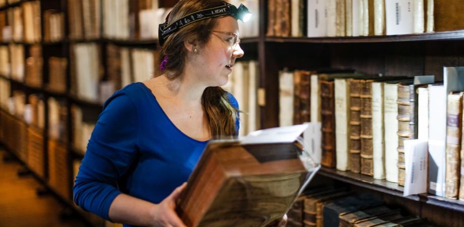 een museummedewerker verzamelt de juiste boeken om te versturen naar Google Books